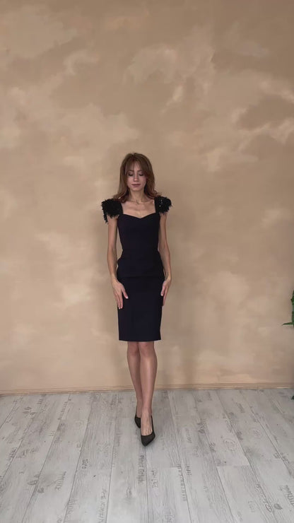 Schwarzes Kleid mit Federapplikationen